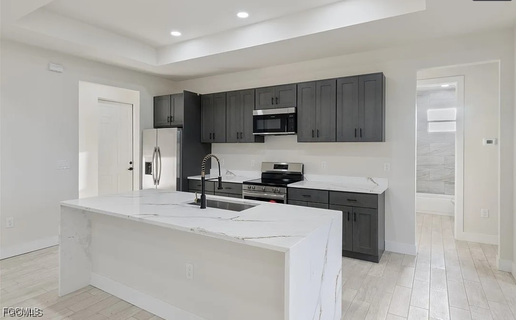2719 42nd Street West Lehigh Acres, FL 33971 - Photo 4 of 20 a kitchen with a sink a stove a microwave and cabinets