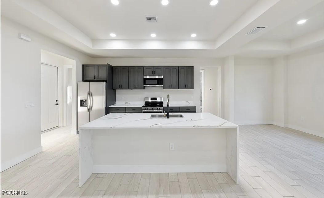 2719 42nd Street West Lehigh Acres, FL 33971 - Photo 5 of 20 a view with kitchen island a sink wooden floor and a refrigerator