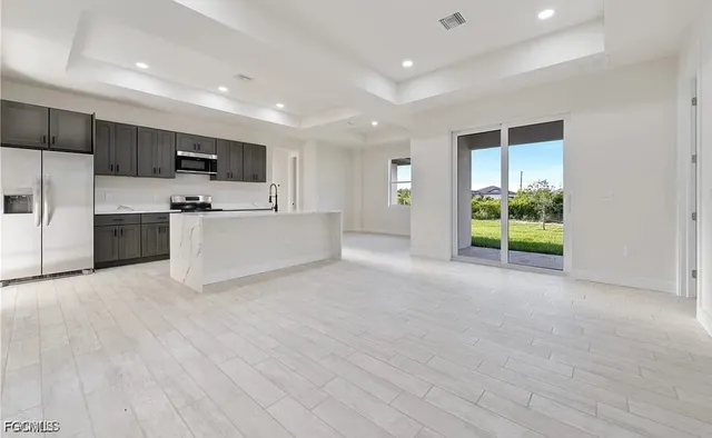 a large white kitchen with a refrigerator a stove a microwave and a sink