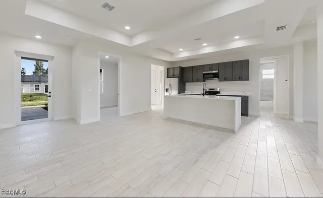 a view of living room kitchen with stainless steel appliances cabinets
