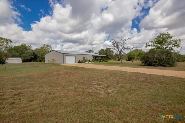 a front view of house with yard and trees