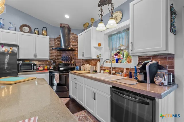 a kitchen with a sink stove top oven and cabinets