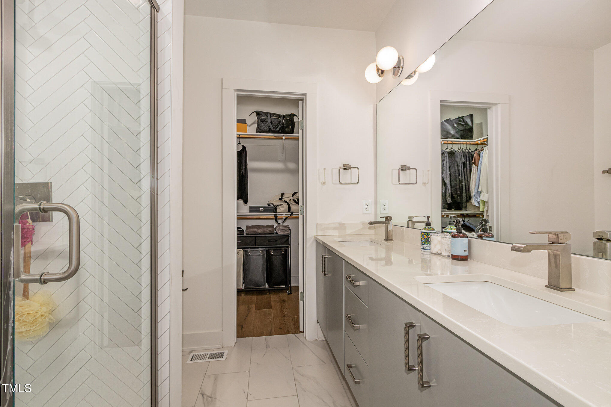 607 North Queen Street Durham, NC 27701 - Photo 17 of 35 a bathroom with a double vanity sink a mirror and a shower