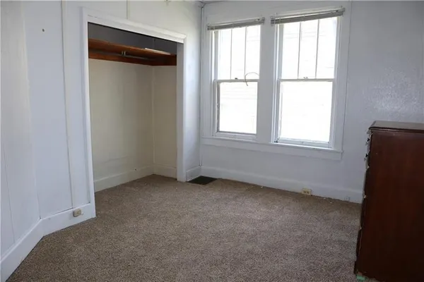 an empty room with windows and closet