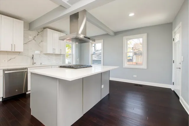 a kitchen with a stove a sink and a window