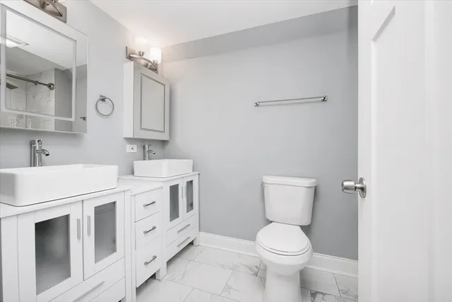 a bathroom with a double vanity sink toilet and mirror