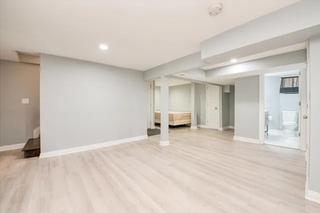 a view of an empty room with closet and bathroom