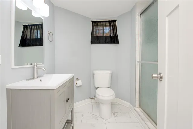 a bathroom with a toilet a sink and mirror