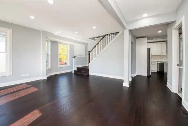 a view of a livingroom with wooden floor and staircase