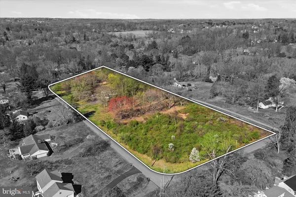 an aerial view of residential houses with outdoor space and trees