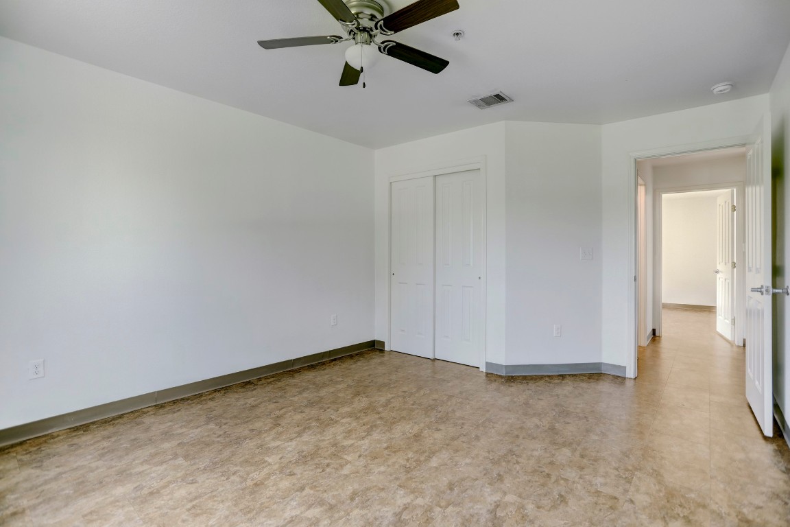 706 West 6th Street, Unit C Taylor, TX 76574 - Photo 9 of 14 Unfurnished bedroom featuring a closet, tile patterned floors, and a ceiling fan