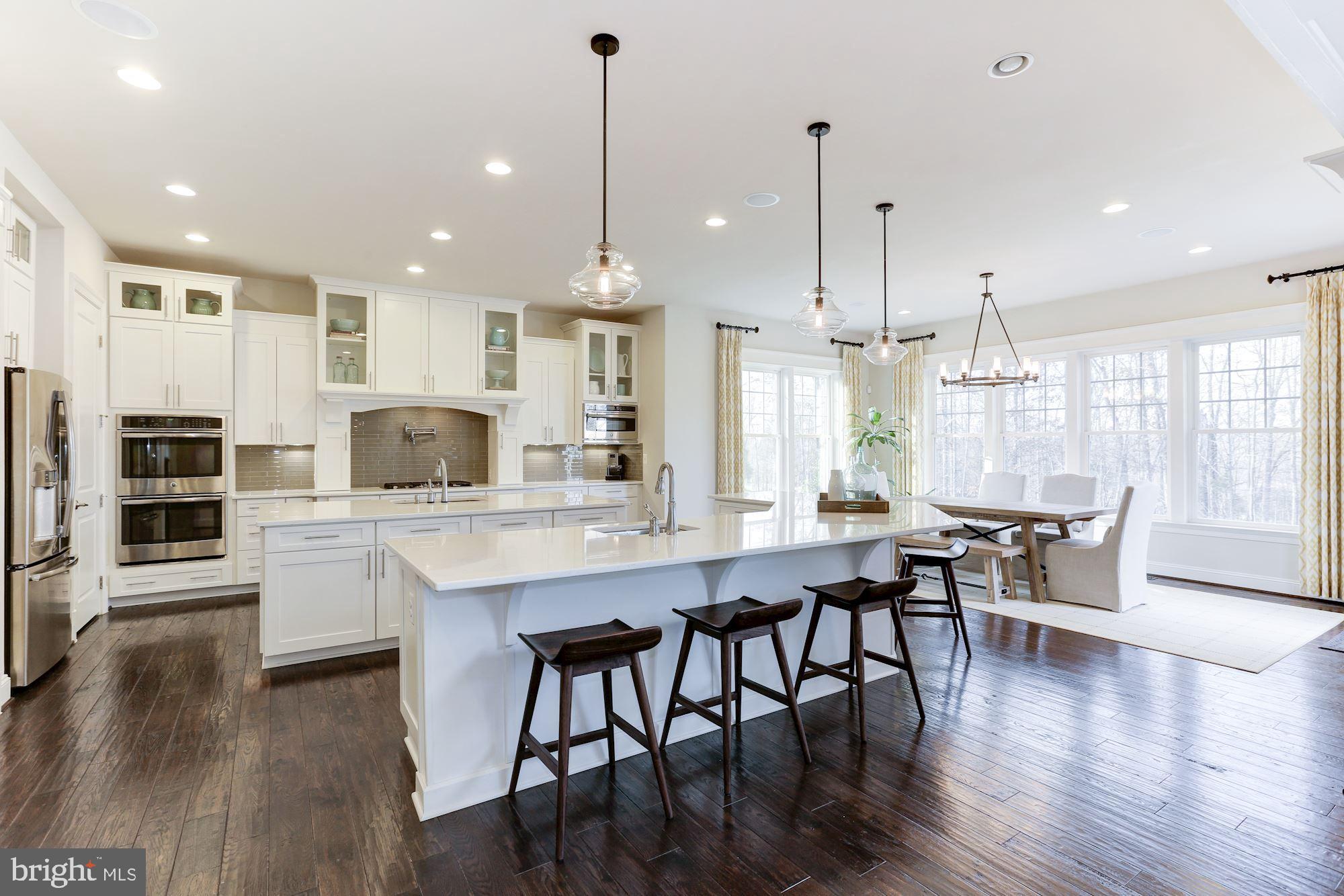 a kitchen with stainless steel appliances granite countertop a kitchen island hardwood floor and a sink