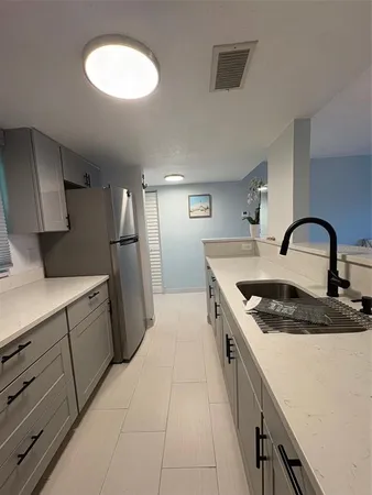 a kitchen with a stainless steel appliances a refrigerator and a stove top oven