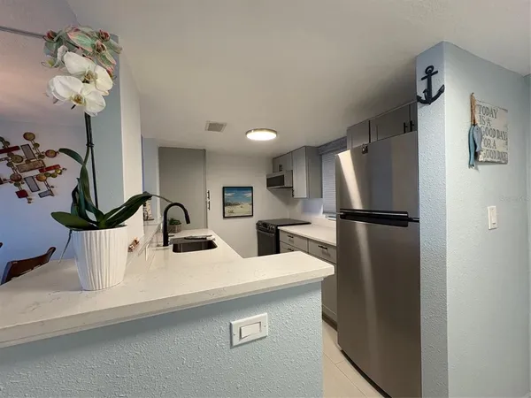 a kitchen with a refrigerator sink and cabinets