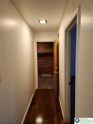 a view of a hallway with wooden floor and staircase
