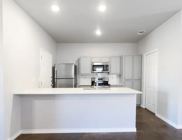 a large kitchen with kitchen island a sink stainless steel appliances and cabinets
