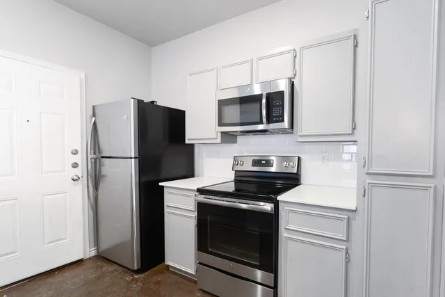 a kitchen with stainless steel appliances a refrigerator stove and microwave