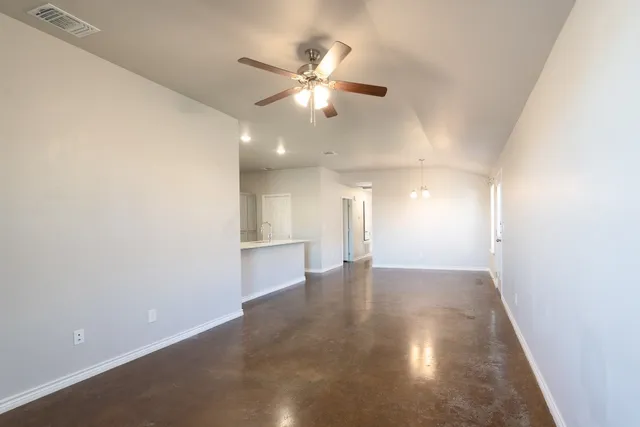 an empty room with a ceiling fan and wooden floor