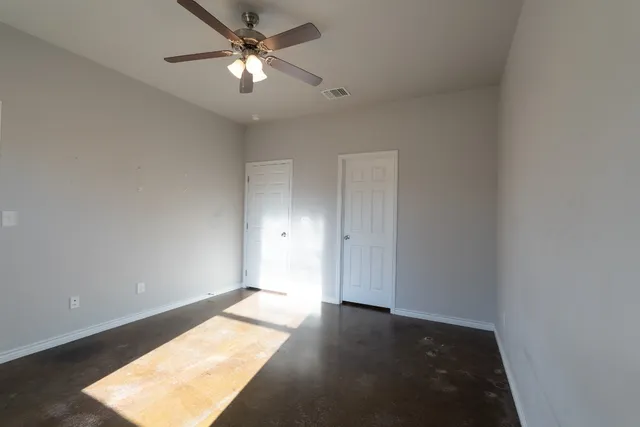 a view of a room with a ceiling fan and a window