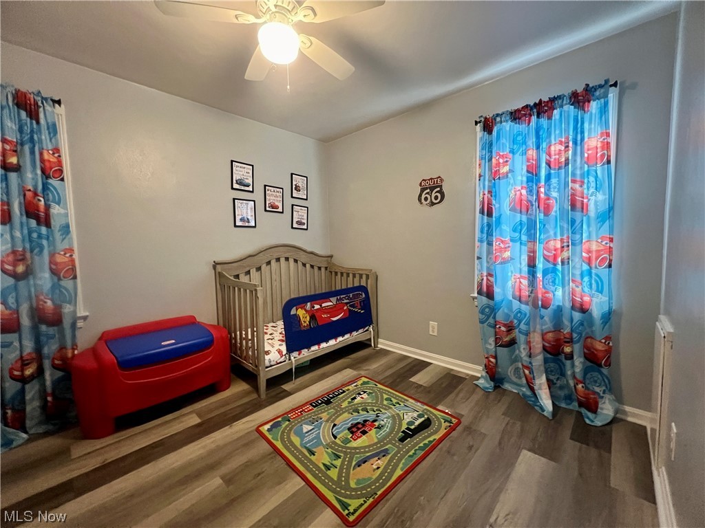 229 Hilliard Road Elyria, OH 44035 - Photo 9 of 28 Bedroom 2 featuring ceiling fan, dark hardwood / wood-style flooring, and a crib