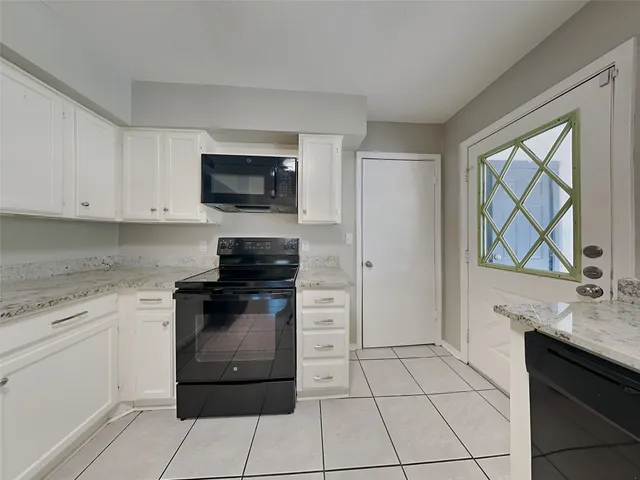 a kitchen with a stove top oven and cabinets