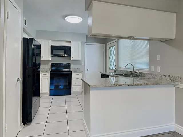 a kitchen with stainless steel appliances granite countertop a sink and a stove top oven