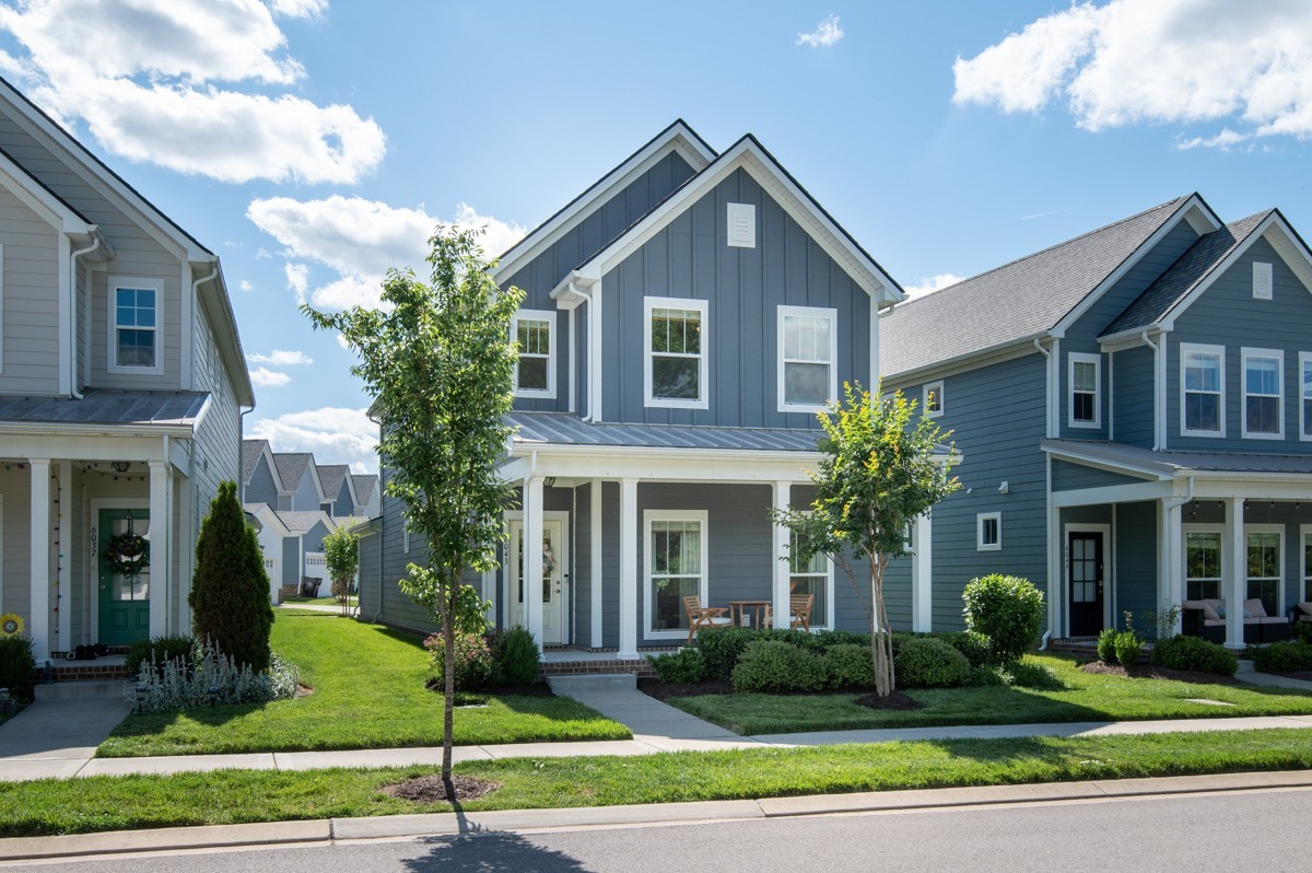 a front view of a house with a yard and plants