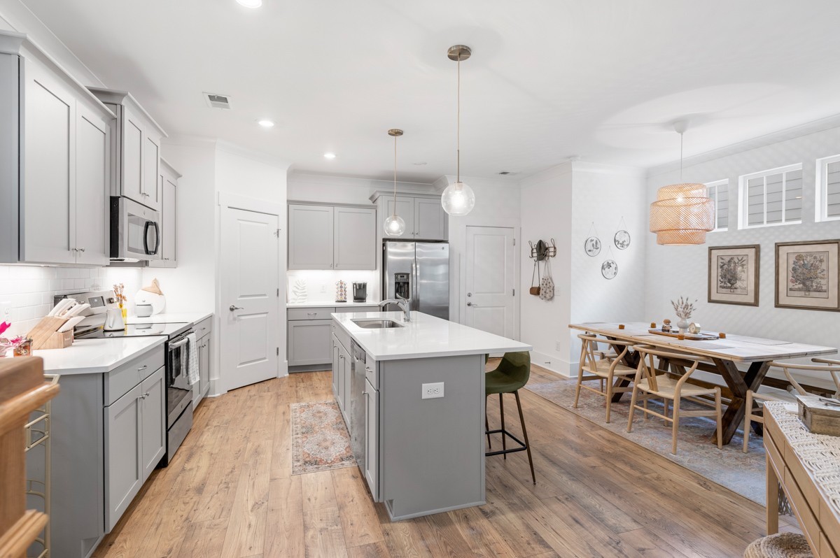 6043 Gracious Drive Franklin, TN 37064 - Photo 15 of 49 a kitchen with stainless steel appliances granite countertop a stove top oven a refrigerator a sink dishwasher and a dining table with wooden floor