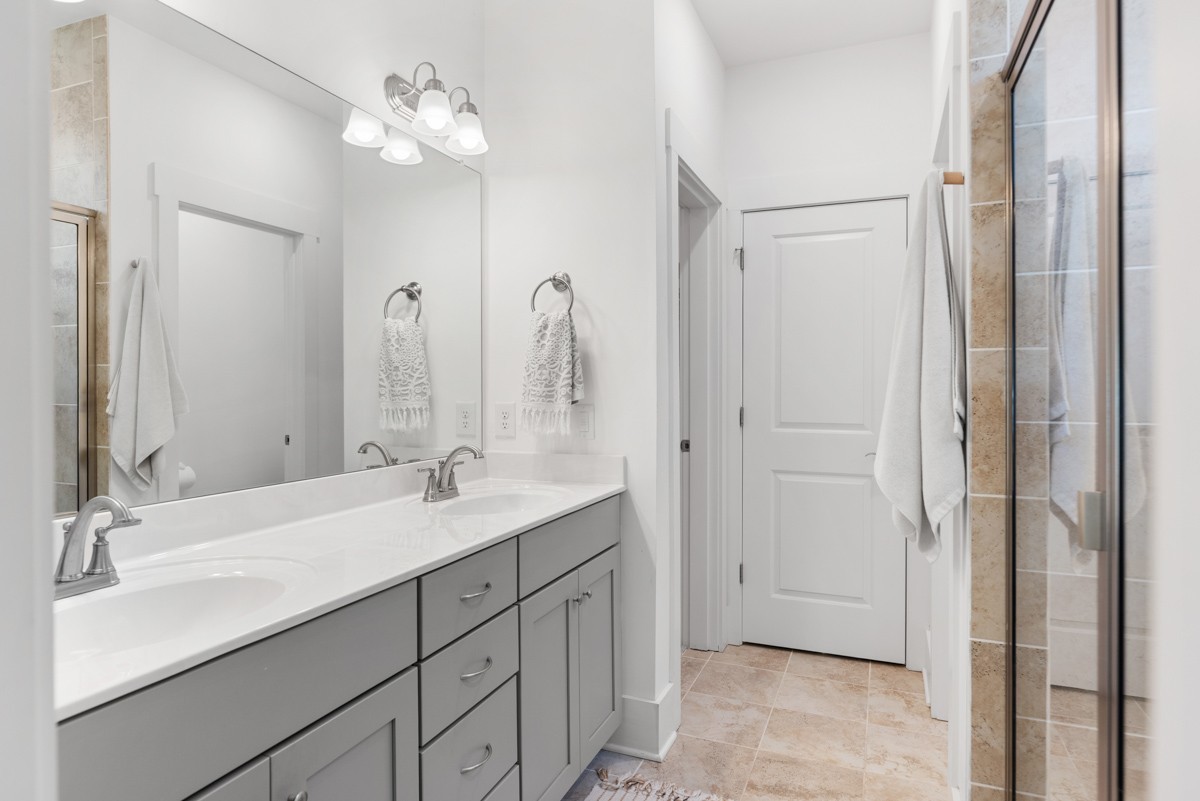 6043 Gracious Drive Franklin, TN 37064 - Photo 26 of 49 a bathroom with double vanity sinks a vanity a lamp and a mirror