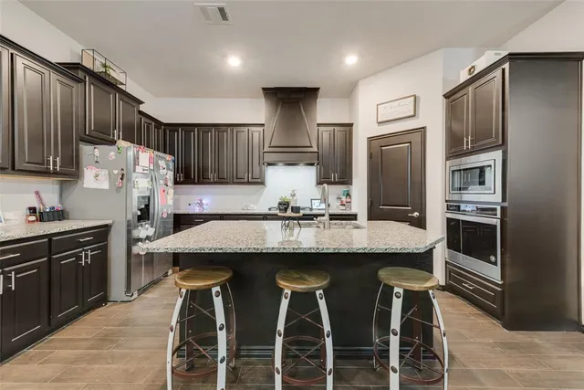 a kitchen with cabinets a sink stainless steel appliances and a center island