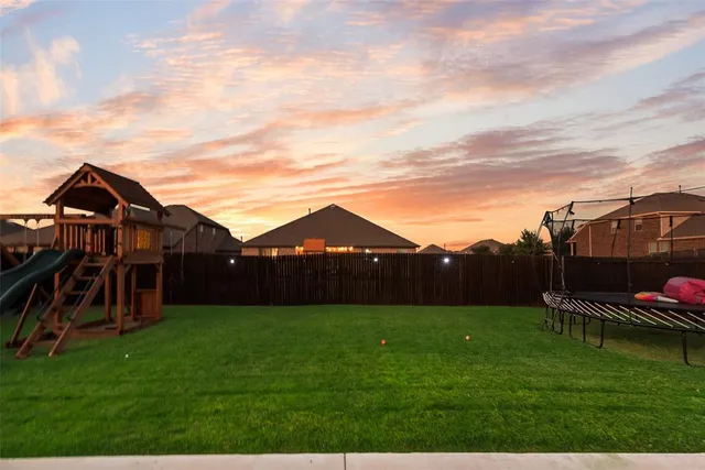 a view of a big house with a big yard and potted plants