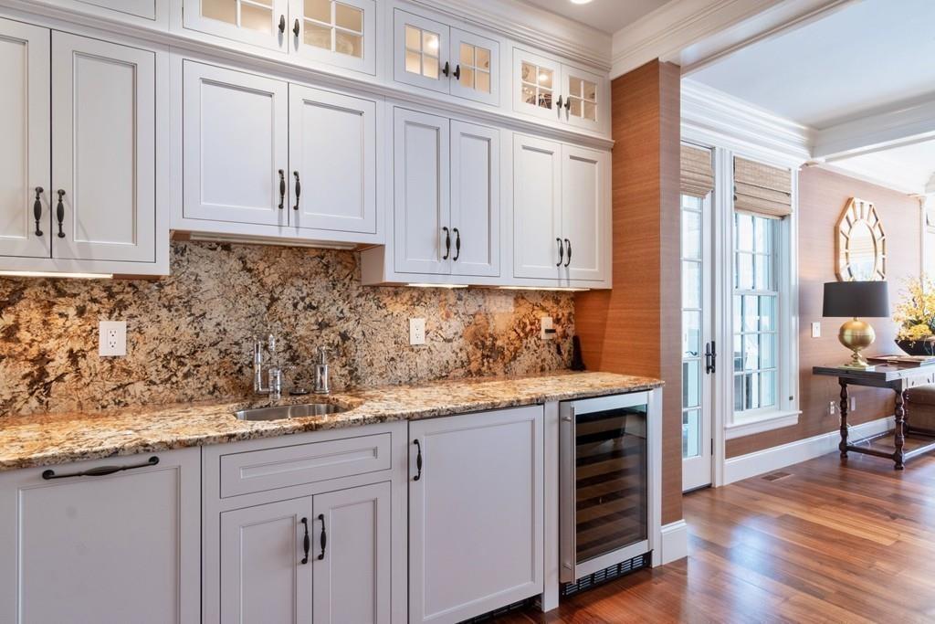 291 Musterfield Road Concord, MA 01742 - Photo 9 of 32 a kitchen with granite countertop white cabinets and stainless steel appliances