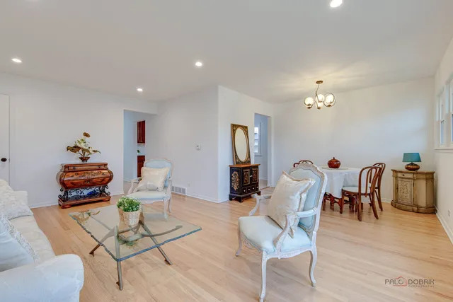 a dining room with furniture a chandelier and wooden floor
