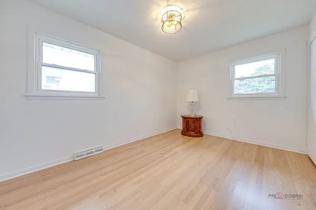 an empty room with wooden floor and window