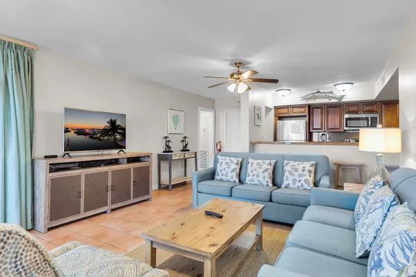 a living room with furniture kitchen view and a flat screen tv