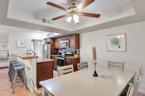 a living room with furniture a chandelier fan and a dining table