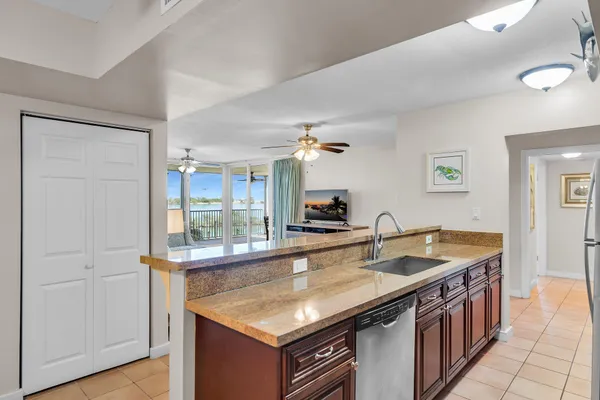 a kitchen with stainless steel appliances granite countertop a sink and a refrigerator