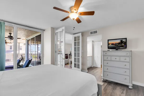 a bedroom with a bed and a flat tv screen on dresser
