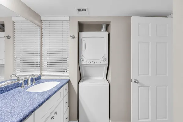 a bathroom with a granite countertop sink and a toilet