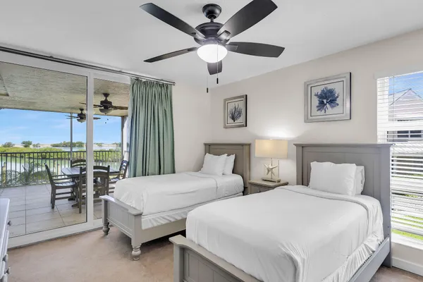 a bedroom with 2 bed and a chandelier
