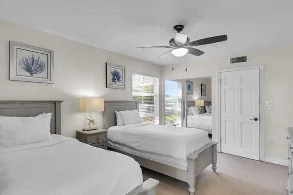 a bedroom with two large bed and a chandelier