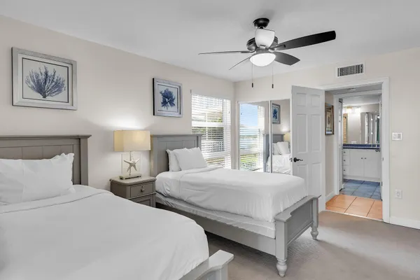 a bedroom with two large bed and a chandelier