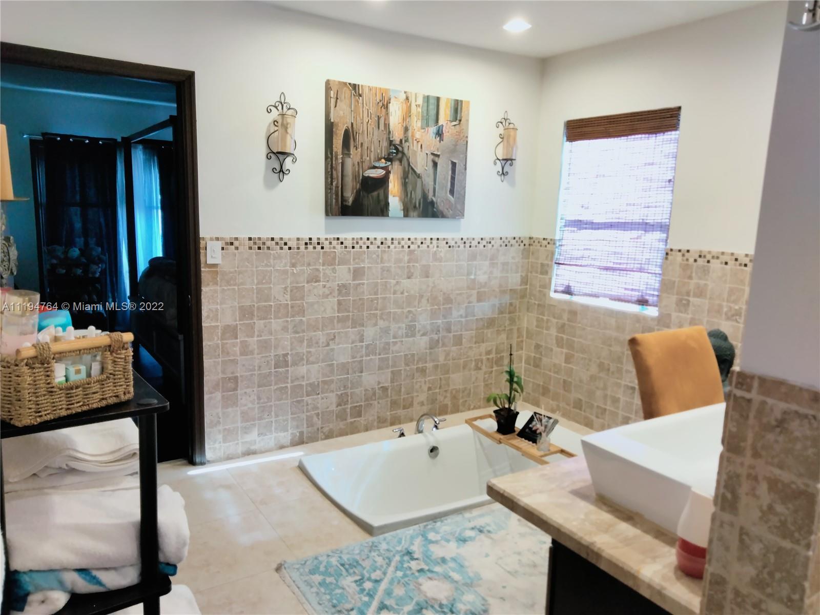 8251 Southwest 34th Terrace Miami, FL 33155 - Photo 11 of 24 a bathroom with a tub sink and mirror