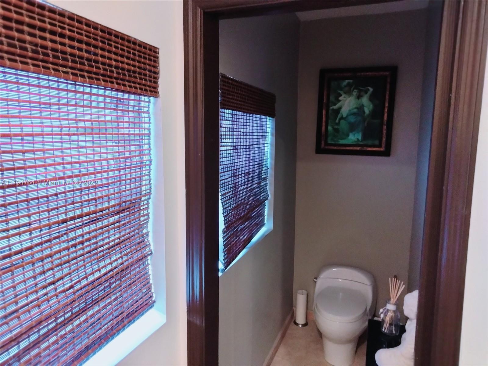 8251 Southwest 34th Terrace Miami, FL 33155 - Photo 12 of 24 a bathroom with a toilet and a shower curtain