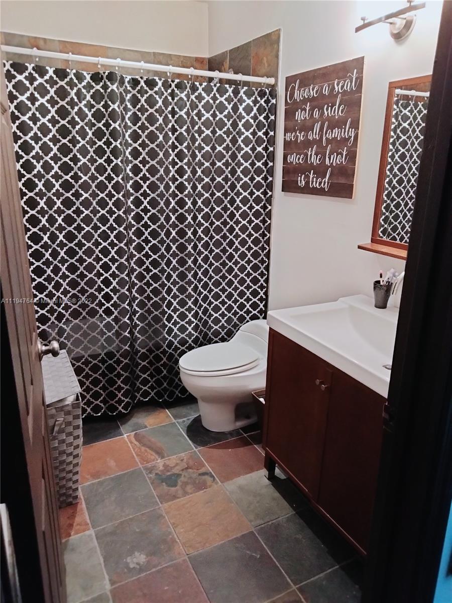 8251 Southwest 34th Terrace Miami, FL 33155 - Photo 16 of 24 a bathroom with a toilet and a shower curtain