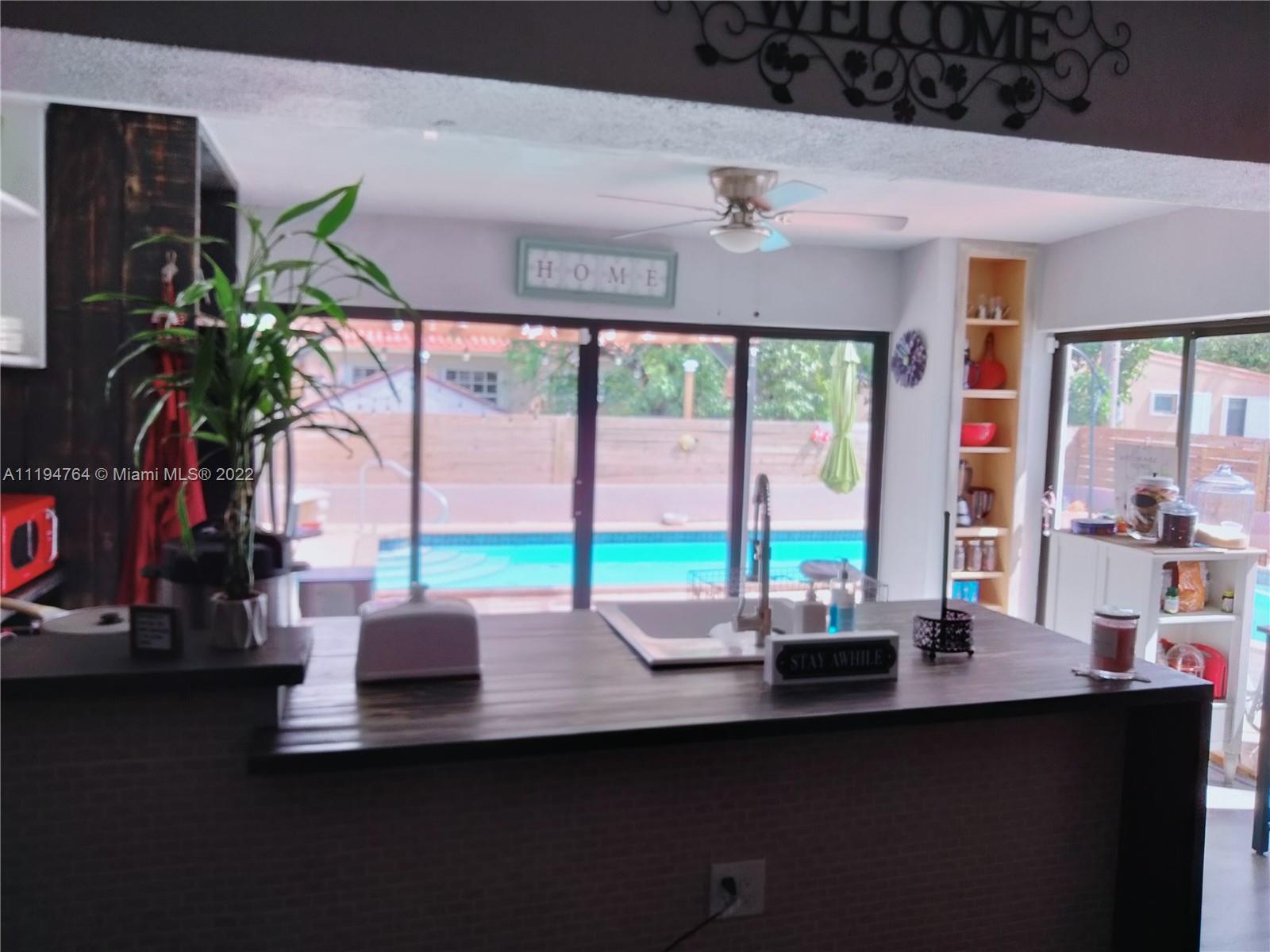 8251 Southwest 34th Terrace Miami, FL 33155 - Photo 4 of 24 a room with lots of potted plants wooden floor and a large window