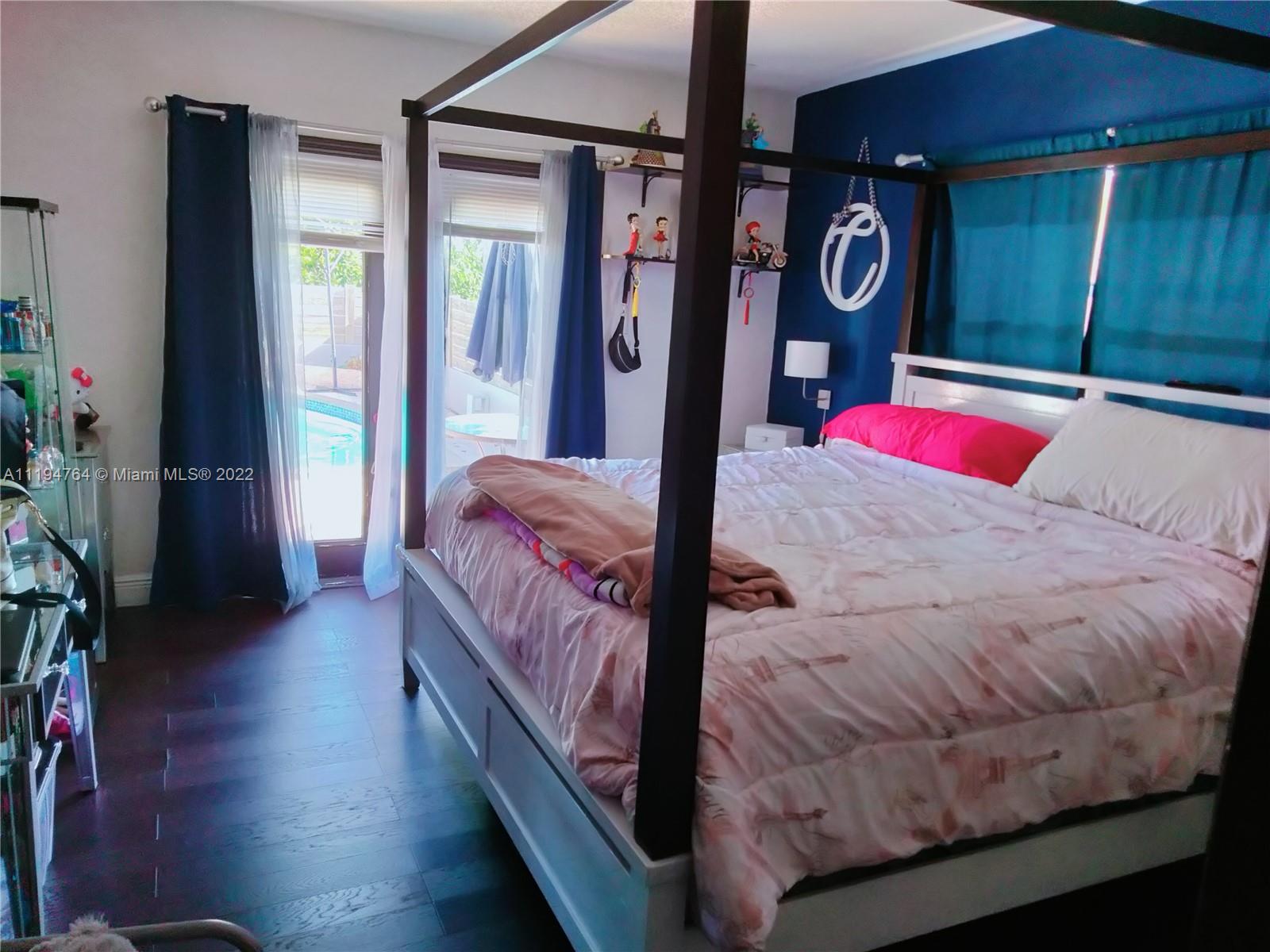 8251 Southwest 34th Terrace Miami, FL 33155 - Photo 10 of 24 a bedroom with a bed and dresser with wooden floor