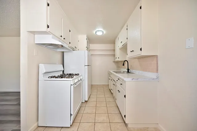 a kitchen with stainless steel appliances a sink stove and cabinets