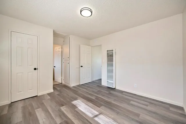 an empty room with wooden floor and closet