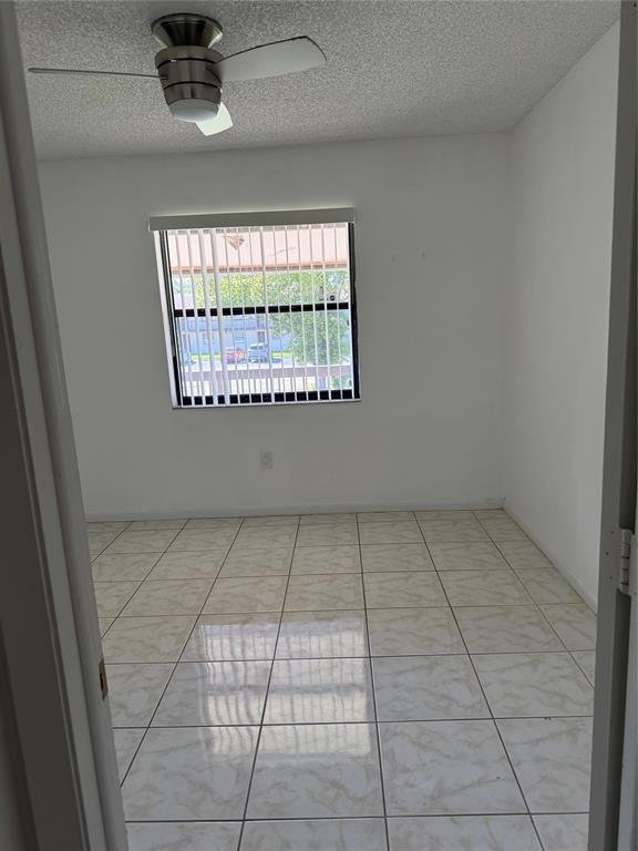 6040 Shaker Wood Circle, Unit 205 Tamarac, FL 33319 - Photo 9 of 14 an empty room with a fireplace and windows